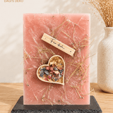 Geschenkskerze mit im Herz verharzten Blüten